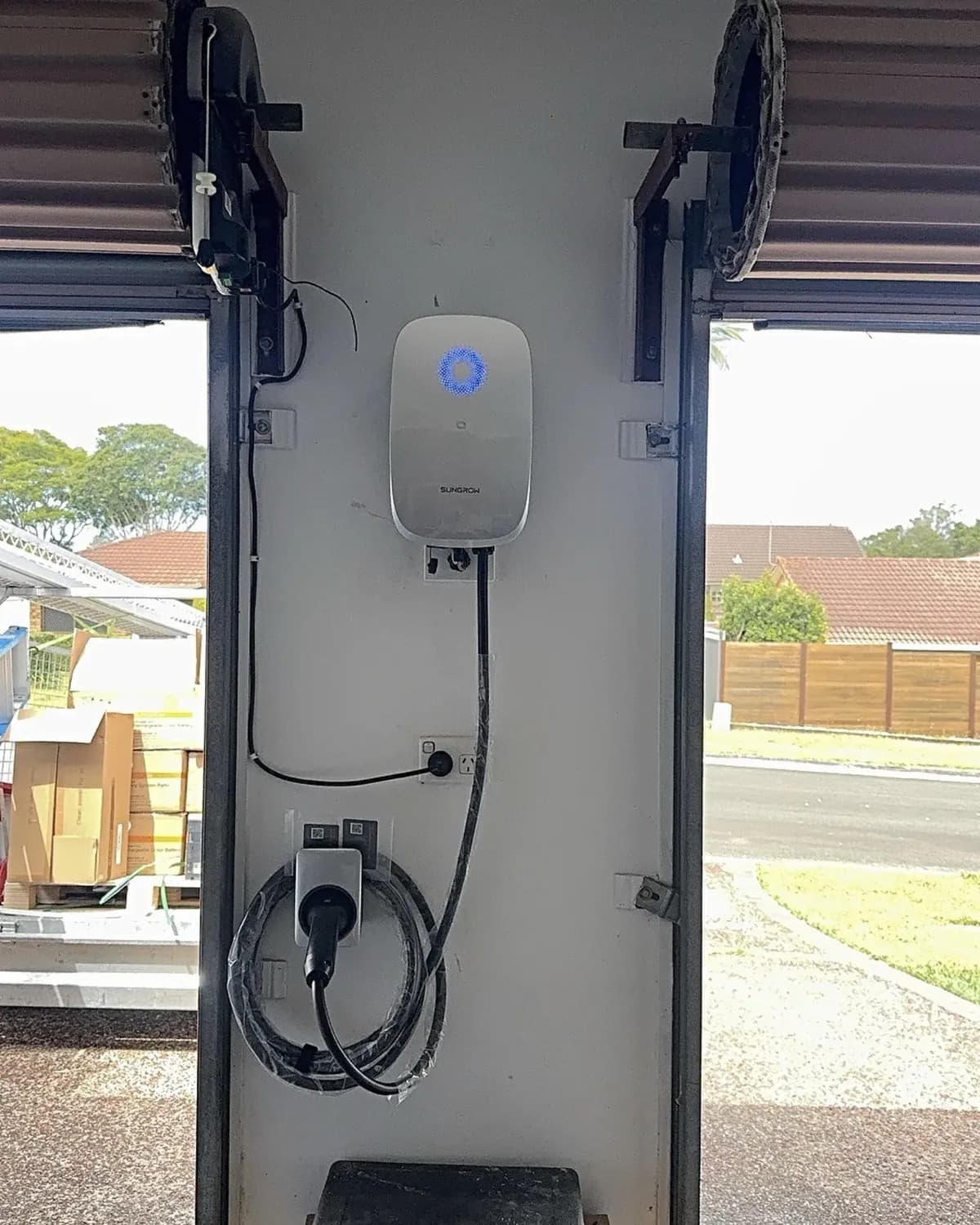 Sungrow AC EV charger installed in a Gold Coast garage with the roller door open